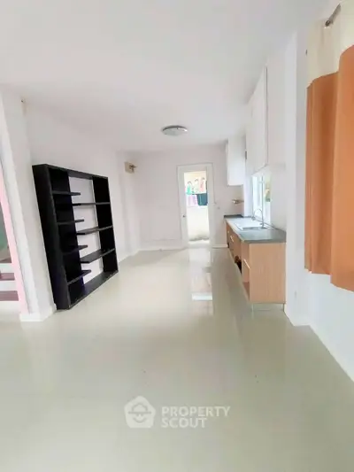 Spacious open-plan living area with modern kitchen and ample natural light.