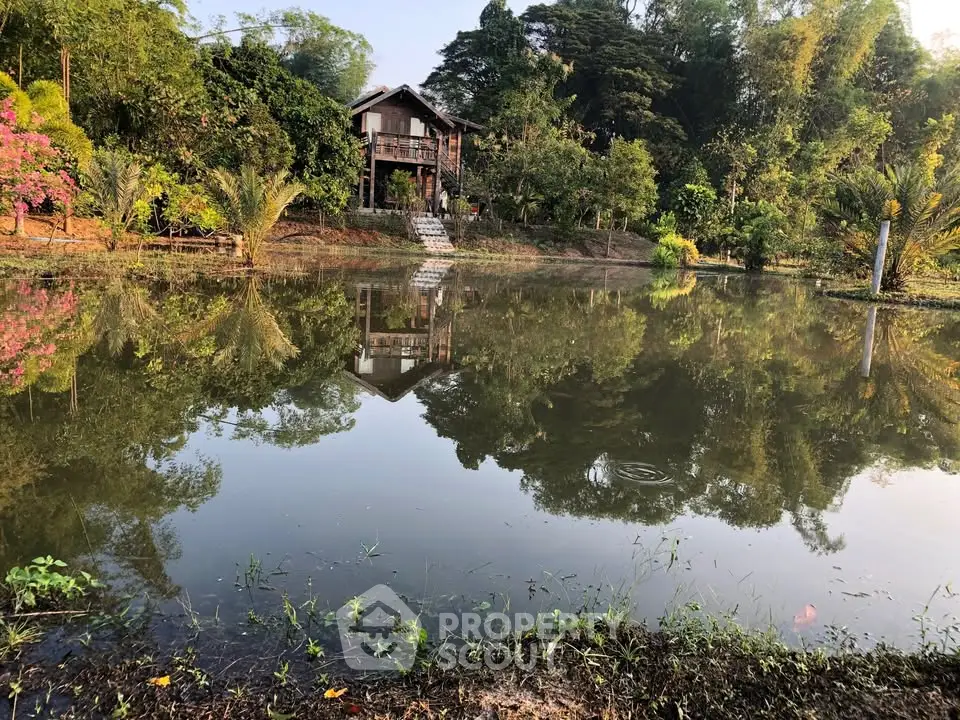 Charming lakeside house with lush greenery and serene water reflections.
