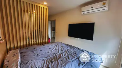 Modern bedroom with wall-mounted TV and air conditioning