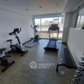 Modern gym with exercise equipment and large window view