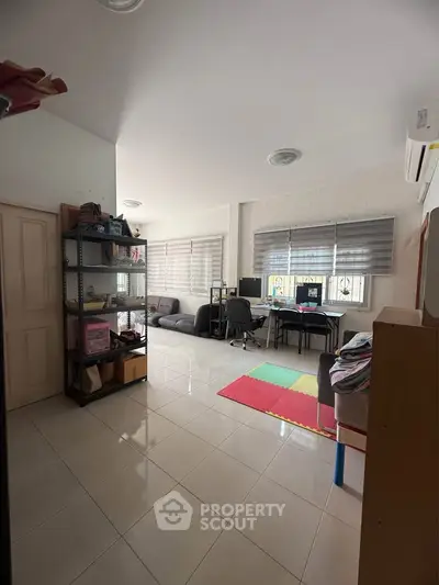 Spacious living room with modern decor and ample natural light, perfect for family gatherings.