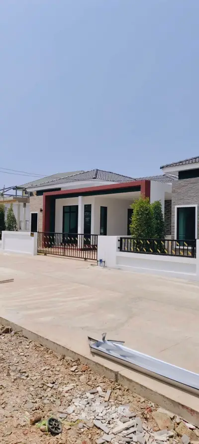 Modern single-story house with sleek design and spacious driveway in a serene neighborhood.