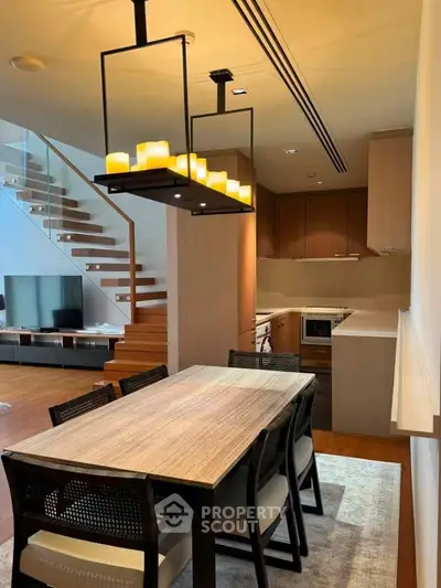 Modern dining area with elegant lighting and open kitchen in luxury home