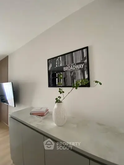 Stylish modern living room with sleek decor and Broadway-themed artwork.