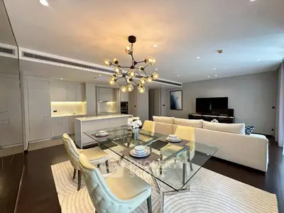 Luxurious open-plan living room with modern chandelier and glass dining table