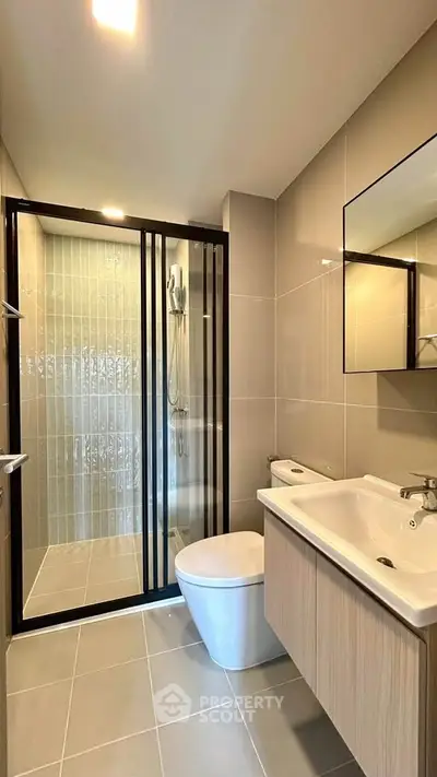 Modern bathroom with sleek design, featuring a glass shower enclosure and stylish vanity.