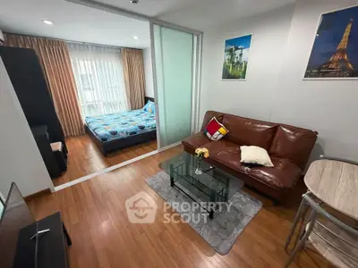 Modern apartment with cozy living room and bedroom, featuring wooden flooring and stylish decor.