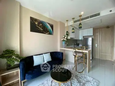 Modern living room with open kitchen, stylish decor, and cozy seating area.