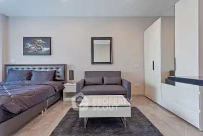 Modern bedroom with stylish decor and sleek furniture, featuring a comfortable bed and cozy seating area.