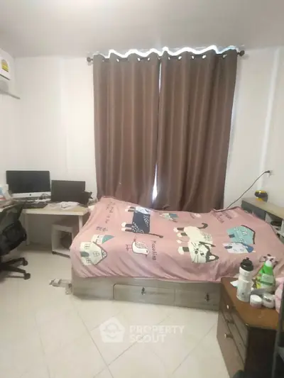 Cozy bedroom with study area, featuring a comfortable bed and dual monitors for work-from-home setup.