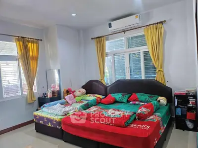 Spacious bedroom with colorful bedding and ample natural light