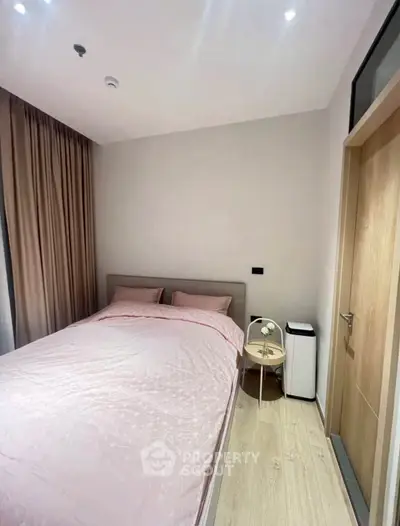 Cozy bedroom with pink bedding and modern decor in a stylish apartment.