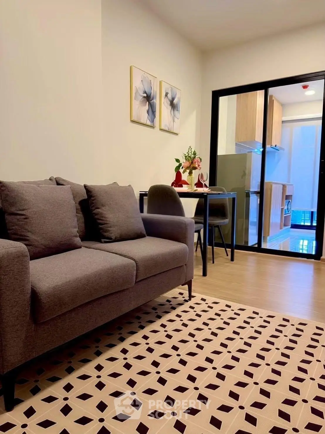 Modern living room with cozy sofa and open kitchen layout in stylish apartment.