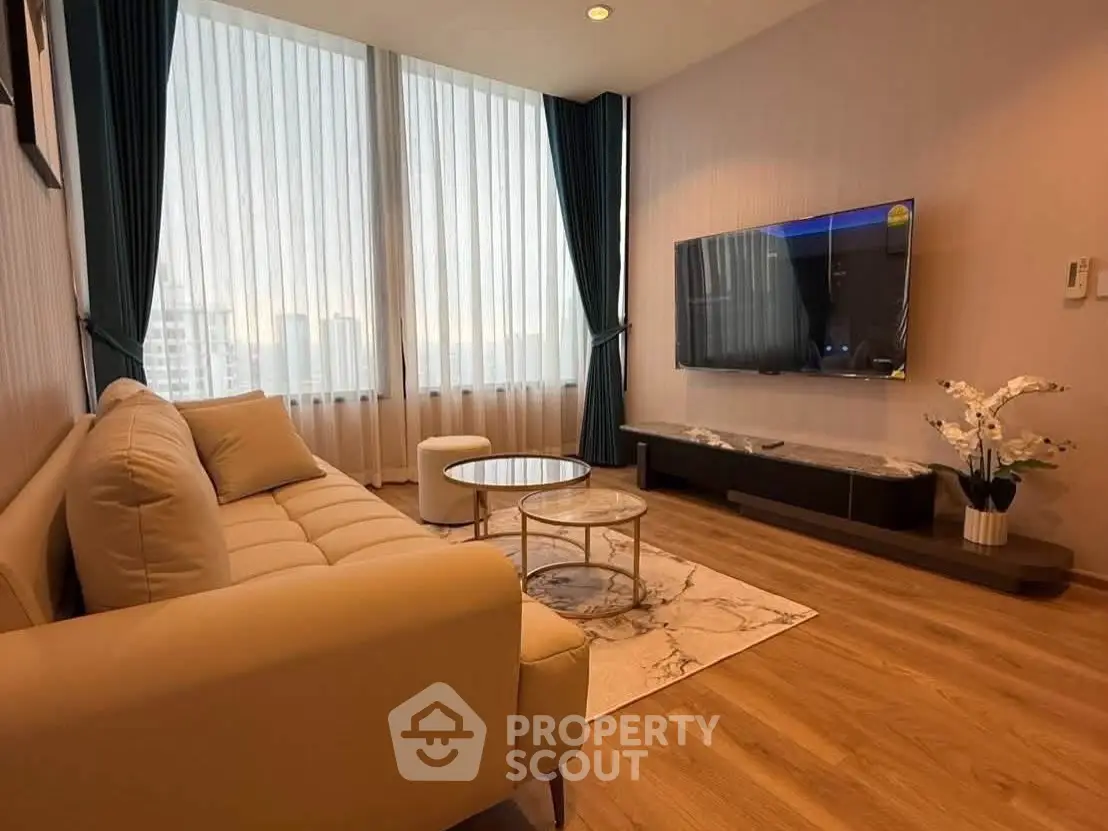 Modern living room with elegant decor and large windows offering natural light.