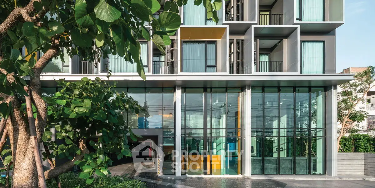 Modern building exterior with glass facade and lush greenery