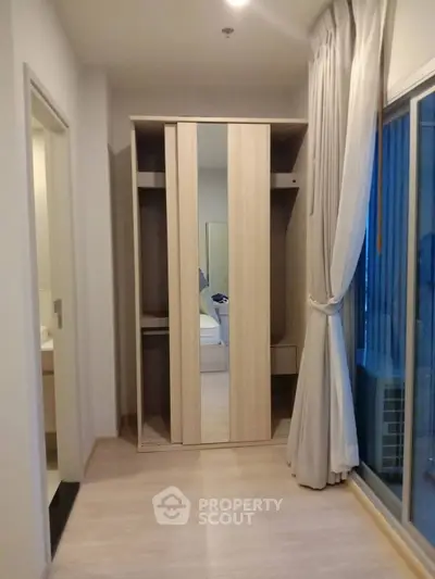 Modern bedroom with mirrored wardrobe and sliding glass door to balcony