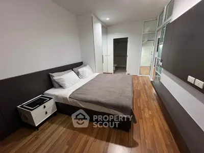 Spacious modern bedroom with wooden flooring and sleek design