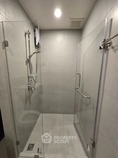 Modern bathroom with sleek glass shower enclosure and elegant tile design.