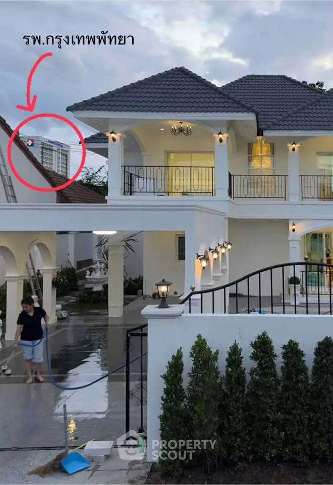Elegant two-story house with balcony and garden, featuring modern architecture and outdoor lighting.