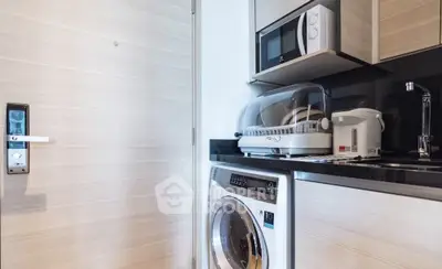 Modern kitchen with washing machine and microwave in compact layout