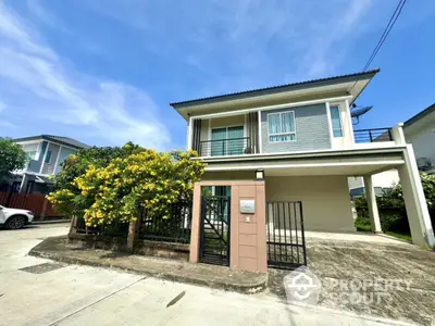 Modern two-story house with spacious driveway and lush garden in a serene neighborhood.