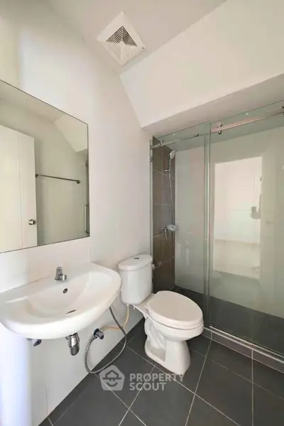 Modern bathroom with glass shower and sleek fixtures in a contemporary home.