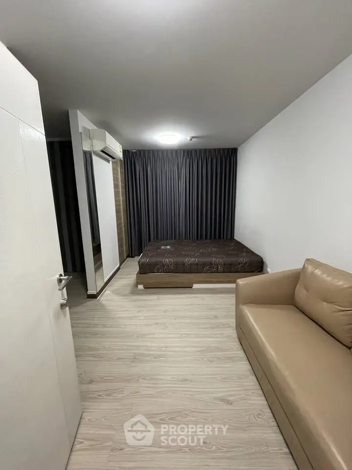 Modern bedroom with minimalist design, featuring a cozy bed and stylish sofa.