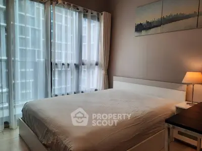 Modern bedroom with large windows and city view, featuring a cozy bed and elegant decor.