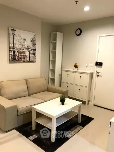 Cozy living room with beige sofa, white coffee table, and modern decor in a stylish apartment.