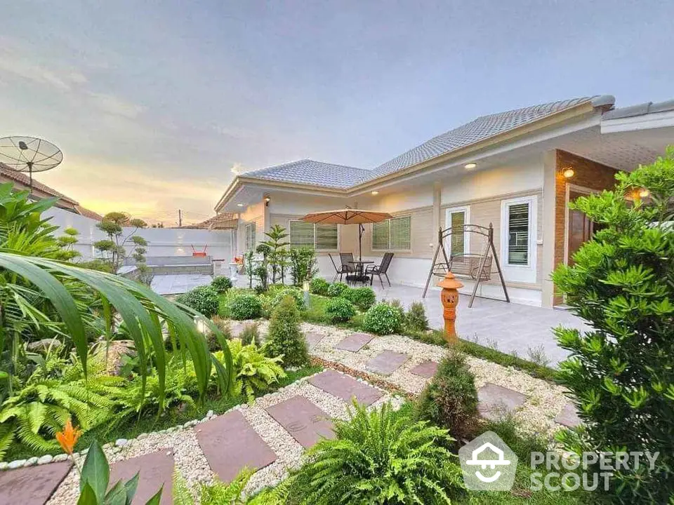 Charming single-story home with lush garden and cozy patio area, perfect for relaxation.