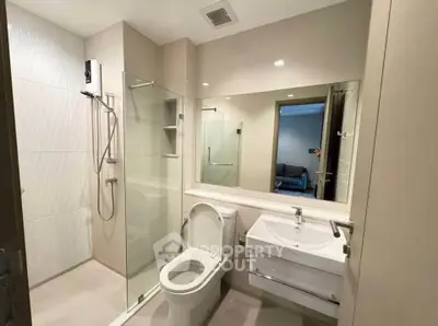 Modern bathroom with glass shower and sleek fixtures in a contemporary apartment.