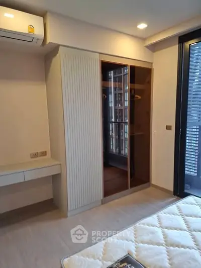 Modern bedroom with built-in wardrobe and balcony access