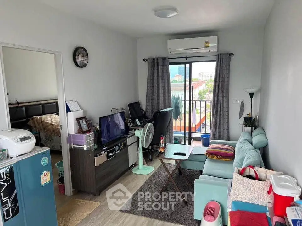 Cozy living room with modern decor and balcony view in a stylish apartment.