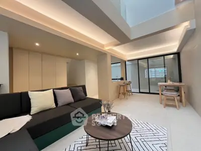 Modern open-plan living room with stylish decor and natural lighting