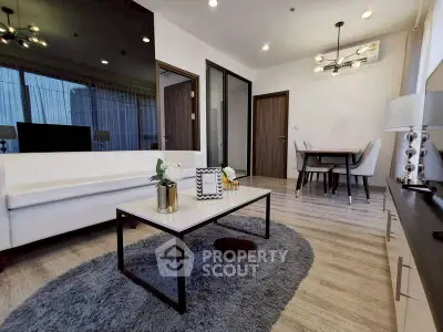 Modern living room with elegant decor and dining area, featuring stylish lighting and cozy ambiance.