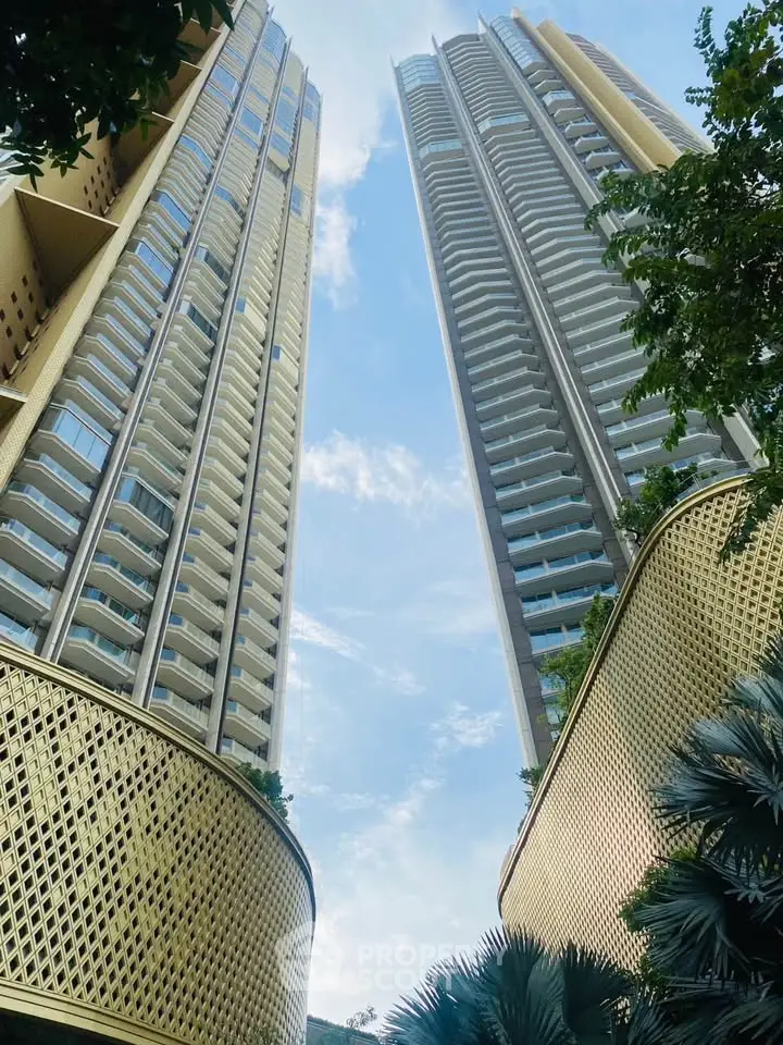Stunning view of modern high-rise residential towers with lush greenery and clear blue sky.