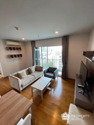 Modern living room with city view, wooden flooring, and stylish furniture in a high-rise apartment.