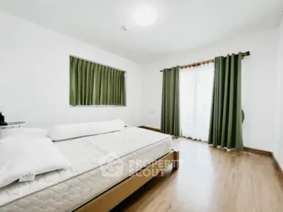 Spacious bedroom with natural light and green curtains, perfect for relaxation.
