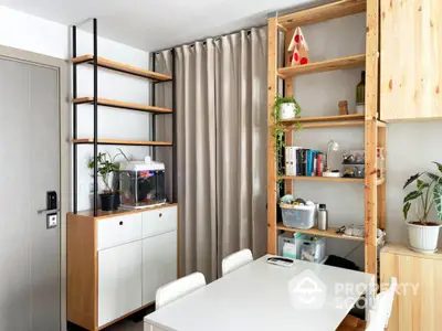 Modern dining area with stylish shelving and neutral curtains