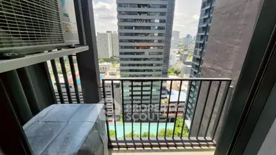 Modern city view from a high-rise balcony with air conditioning unit and protective cover.