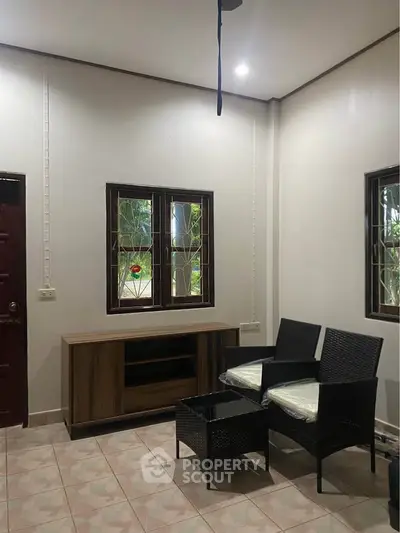 Cozy living room with wicker furniture and natural light from windows.