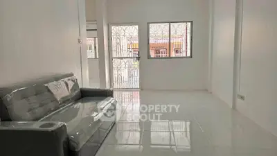 Spacious living room with modern sofa and large windows offering natural light.