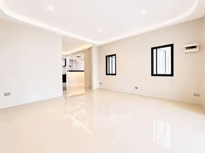 Spacious modern living room with sleek design and ample natural light.