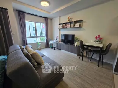 Modern living room with stylish decor, cozy seating, and natural light from large window.