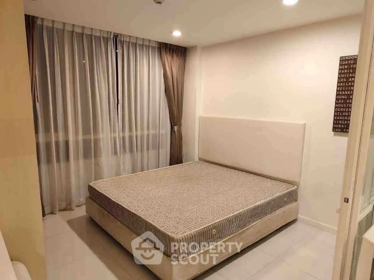 Modern bedroom with large window and elegant curtains in a stylish apartment.