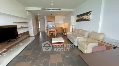 Spacious modern living room with open kitchen, sleek furniture, and stylish decor in a contemporary apartment.