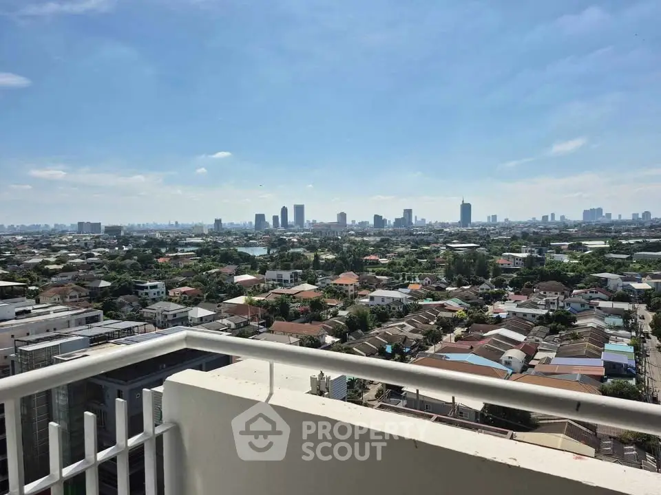 Stunning cityscape view from a high-rise balcony, showcasing urban skyline and residential areas.