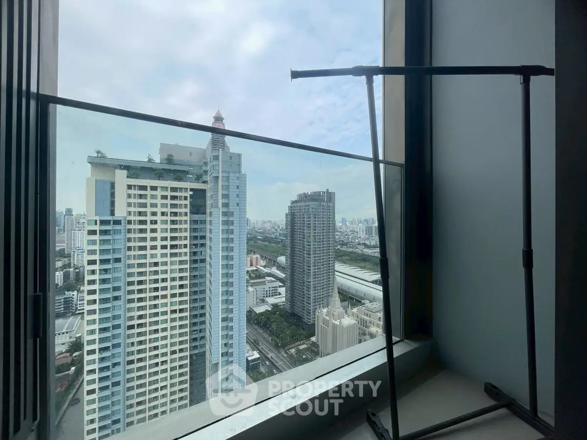 Stunning cityscape view from high-rise apartment window with skyline and modern architecture.