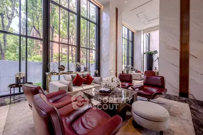 Luxurious living room with high ceilings, large windows, and elegant furniture in a modern home.