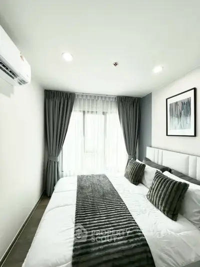Modern bedroom with elegant decor and natural light, featuring plush bedding and stylish curtains.